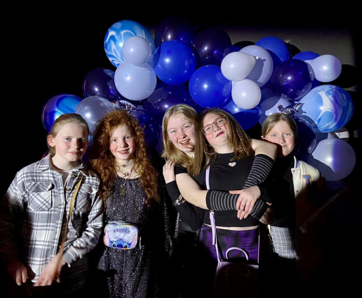 Students stood in front of a balloon arrangement with a dark background