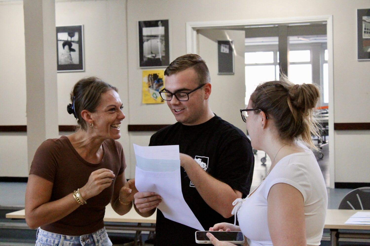 Two Post-16 students are pictured smiling together with a female member of staff, after having just opened their A-Level results.