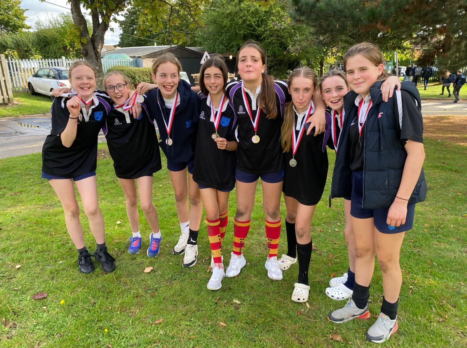A group of girls in rugby kits smiling for a photo