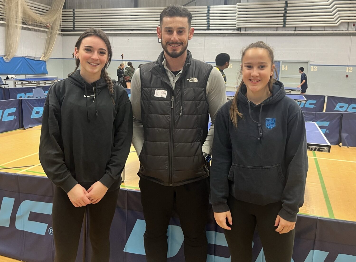 A photo of 3 people smiling at the Table Tennis Regional Finals