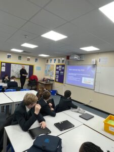 Students sat at desks watching a presentation