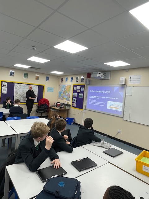 Students sat at desks watching a presentation
